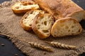 Italian traditional ciabatta bread with sliced Ã¢â¬â¹Ã¢â¬â¹pieces and ears of wheat lie on a jute napkin on a table Royalty Free Stock Photo